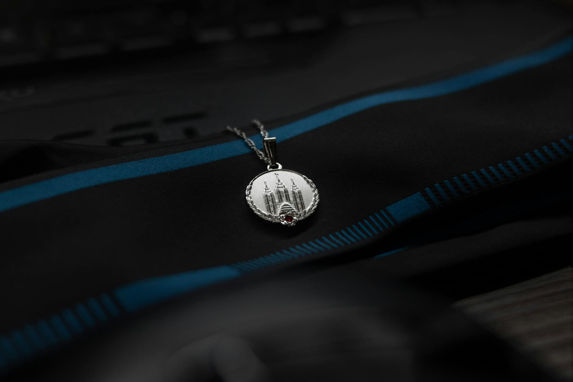 Srebrny wisiorek z grawerunkiem budynku na czarnym materiale