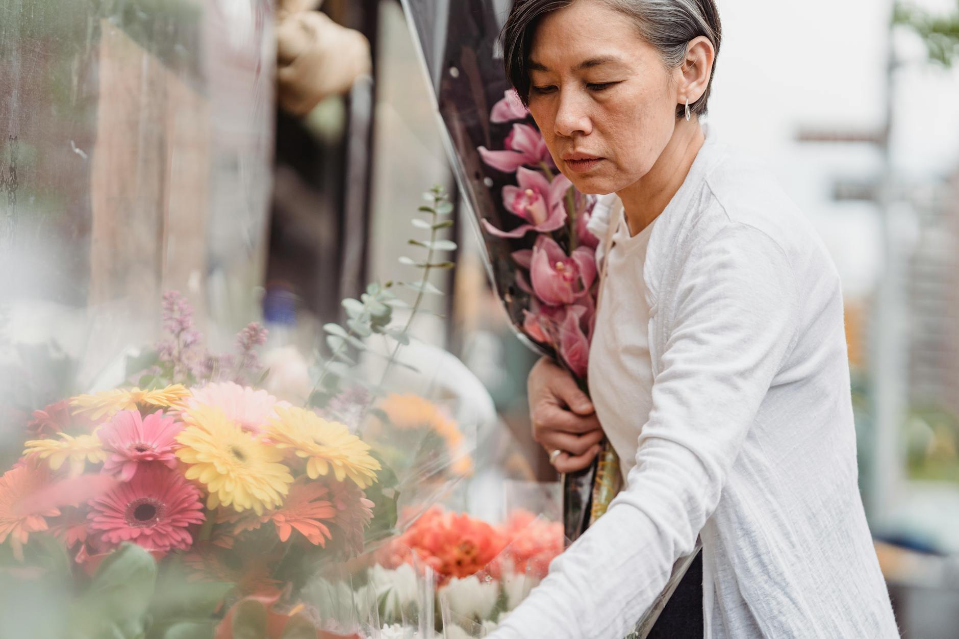 Kobieta wybiera bukiet kwiatów w kolorowej kwiaciarni