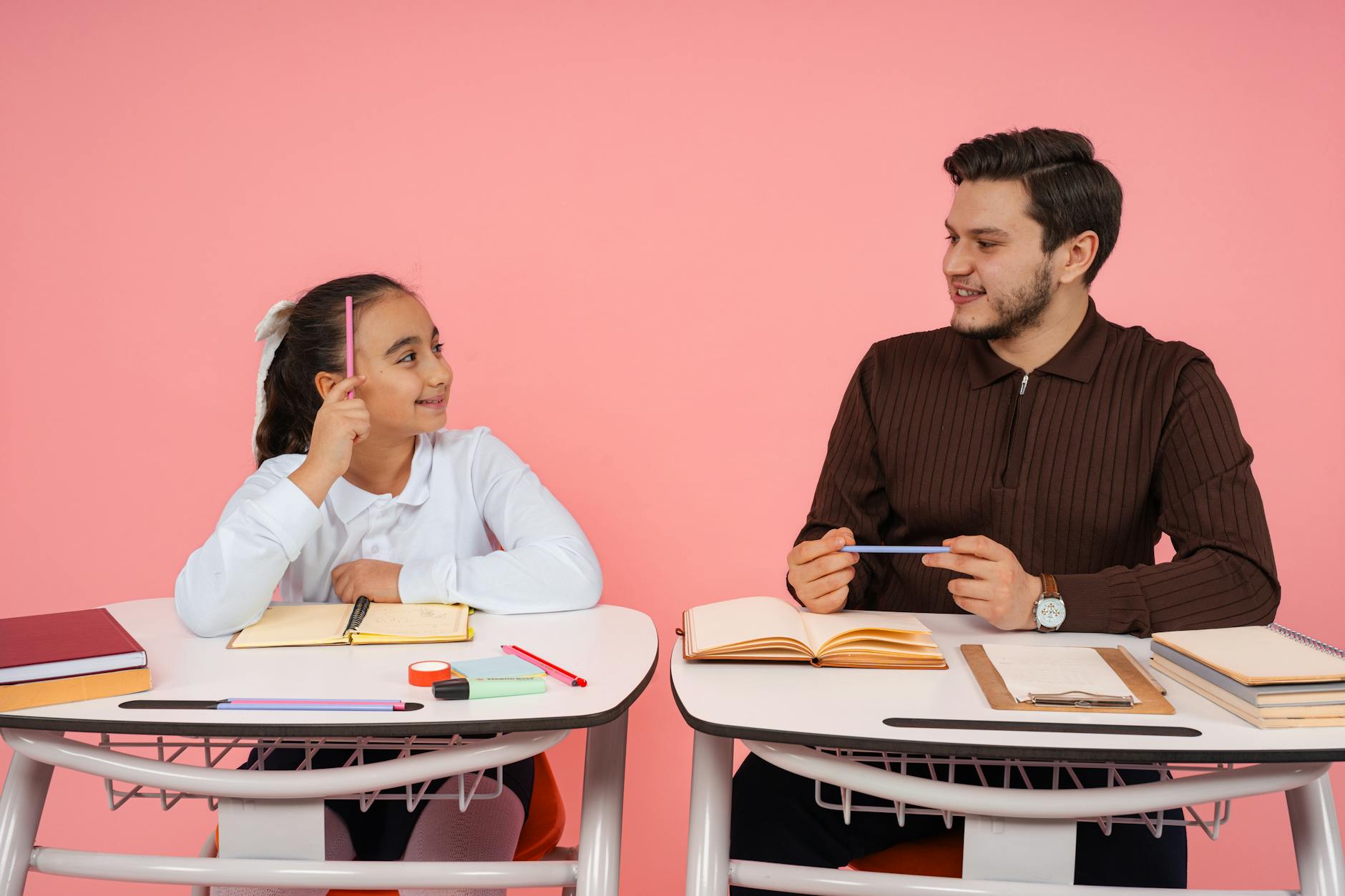 Nauczyciel i uczeń żywo rozmawiają w szkolnej klasie