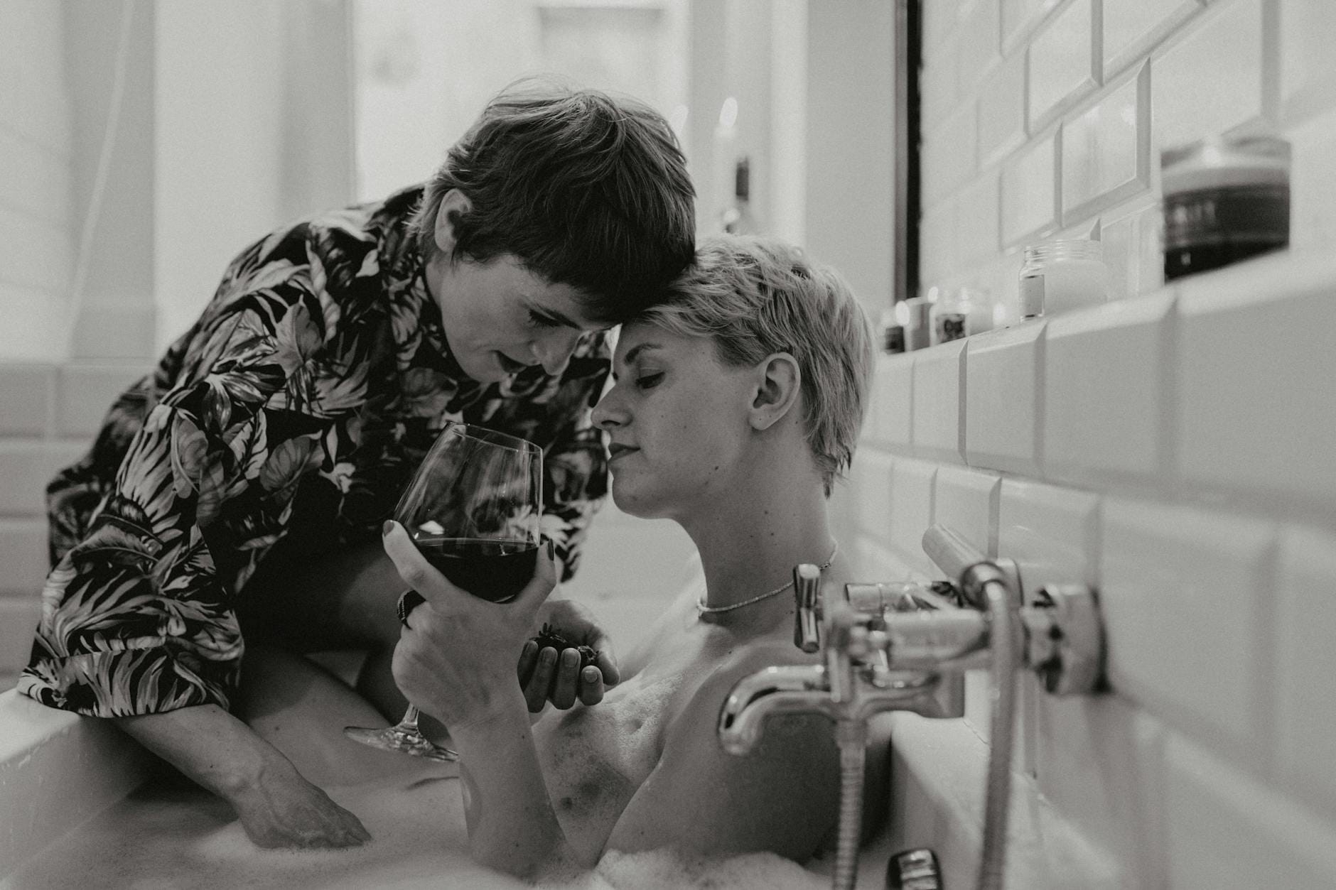 Para LGBT w romantycznej kąpieli z winem w wannie