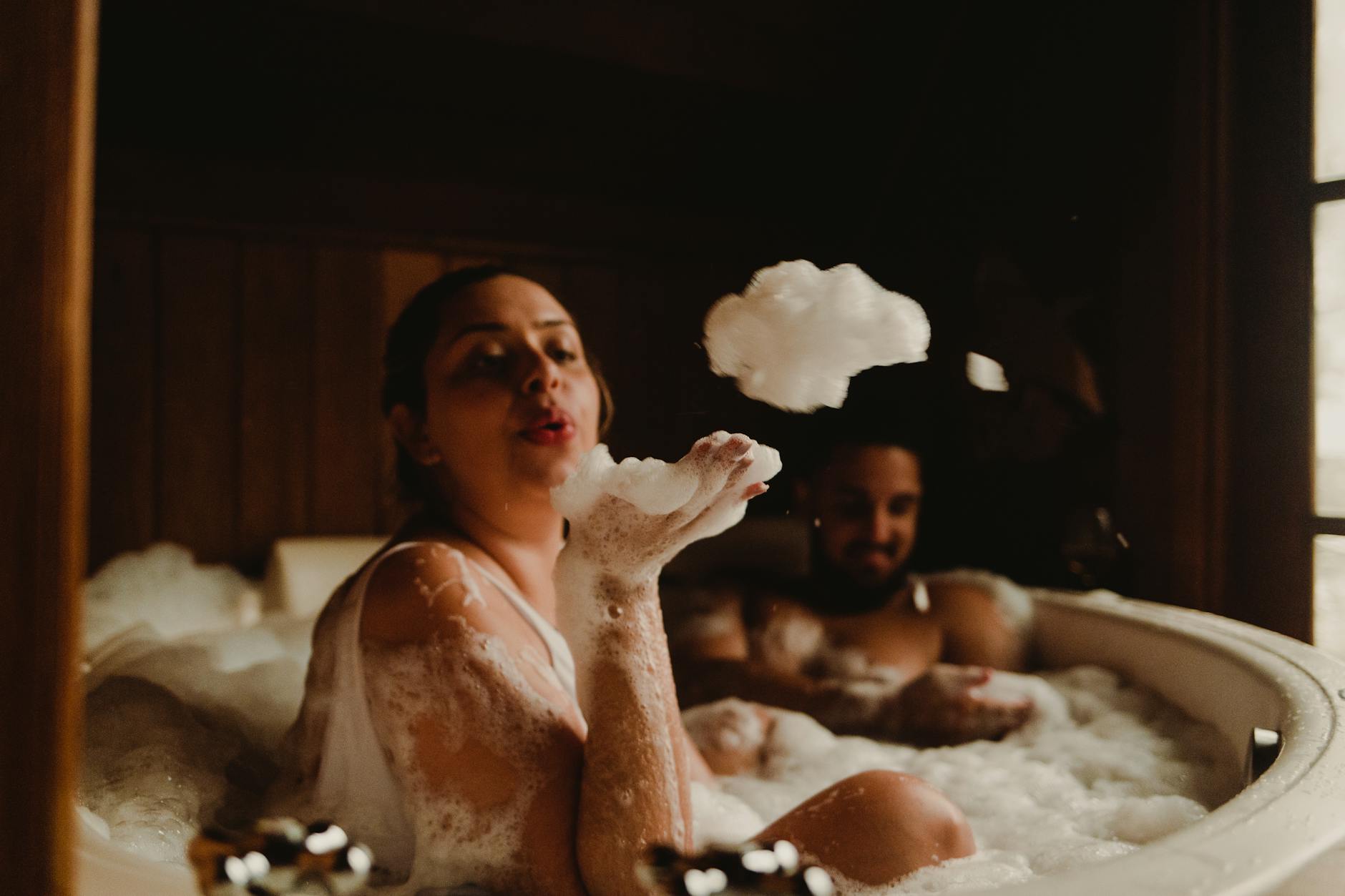 Aromatyczna kąpiel dla dwojga: prezent idealny na zimowe wieczory Para relaksuje się wspólnie w wannie pełnej piany