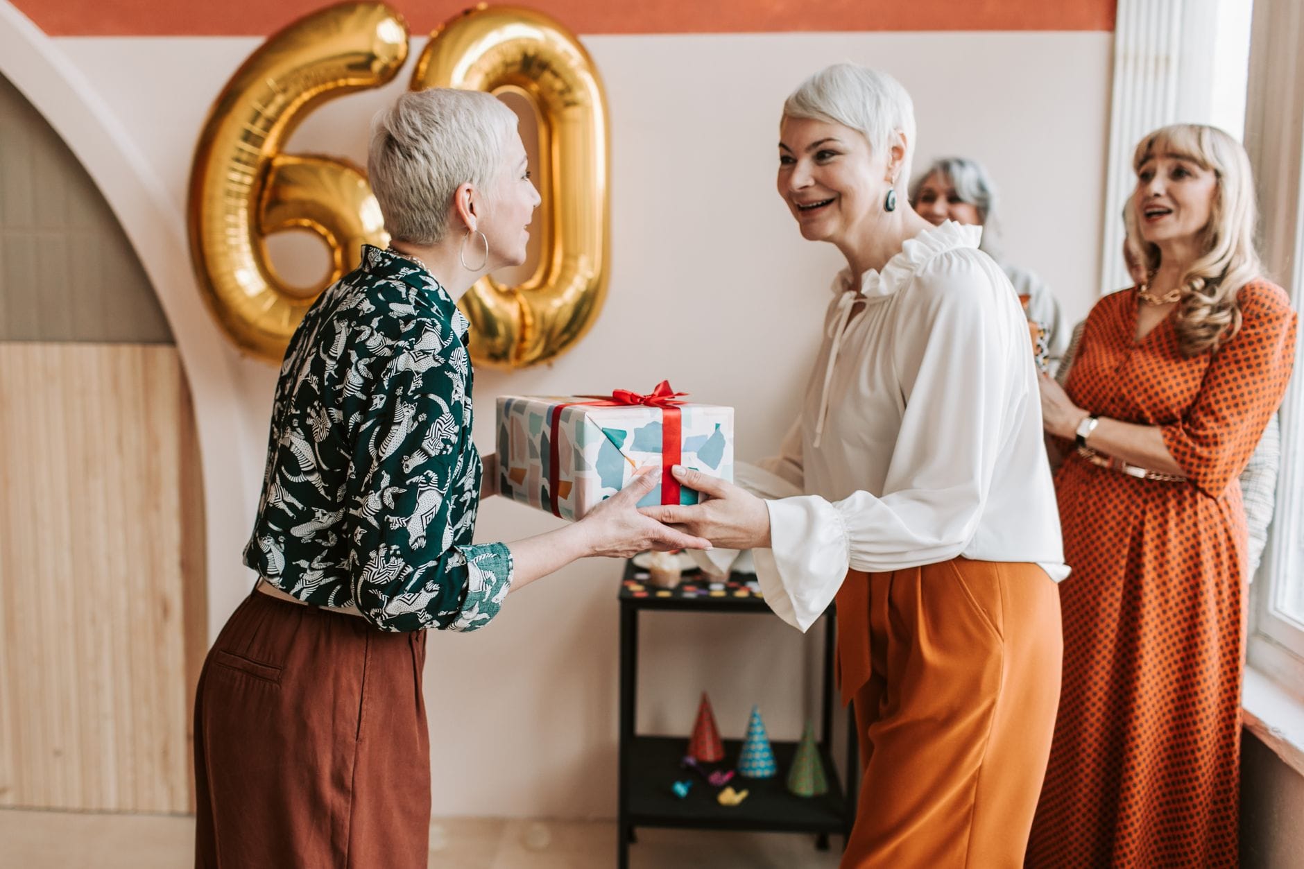 Seniorki świętujące 60. urodziny i wręczające sobie prezenty