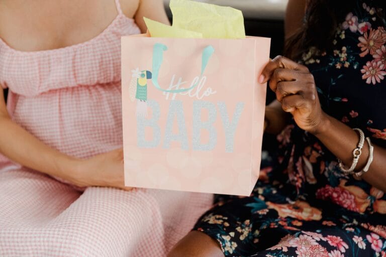 Ciężarna kobieta z torbą prezentową na baby shower